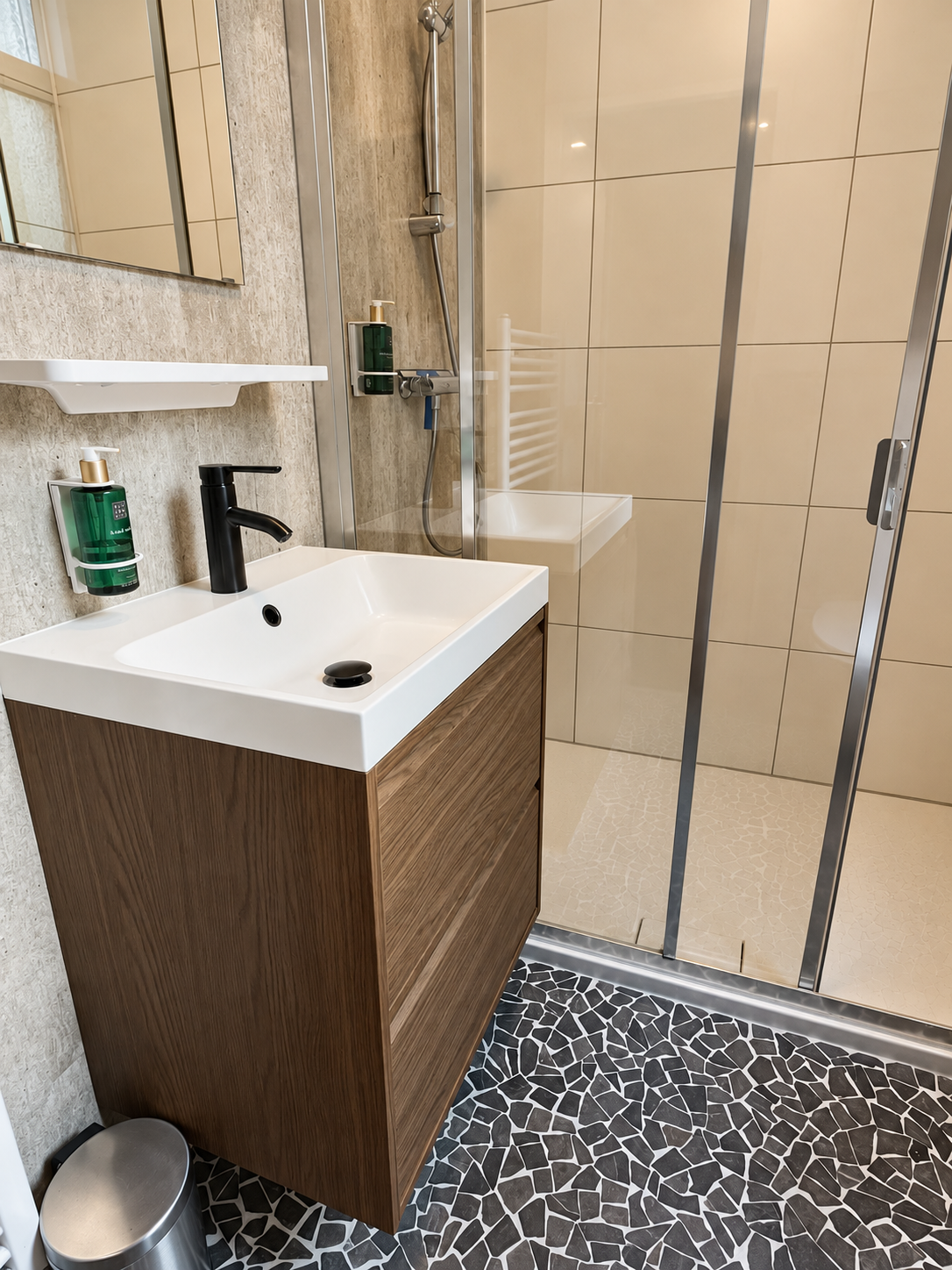 Badkamer met douche, houten wastafelmeubel en Rituals producten