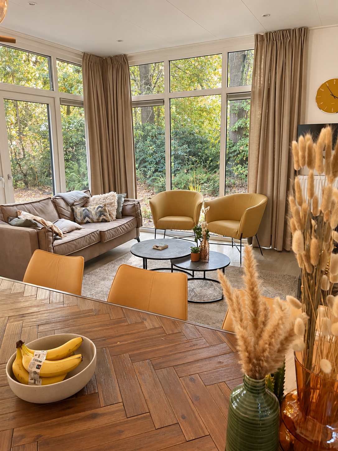 Zithoek met bank en fauteuils aan de grote ramen