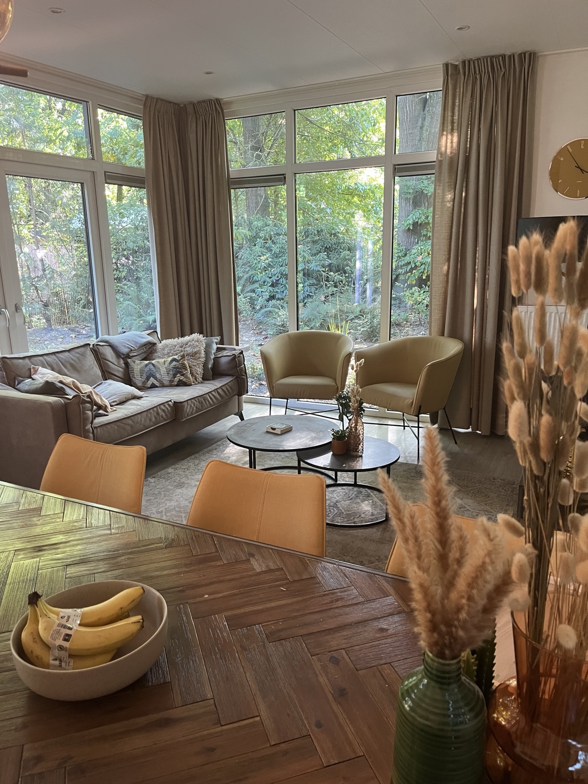 Zithoek met bank en fauteuils aan de grote ramen